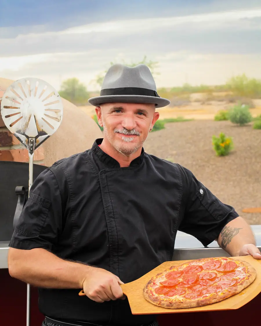 Local Hive chef holding a fresh pepperoni pizza
