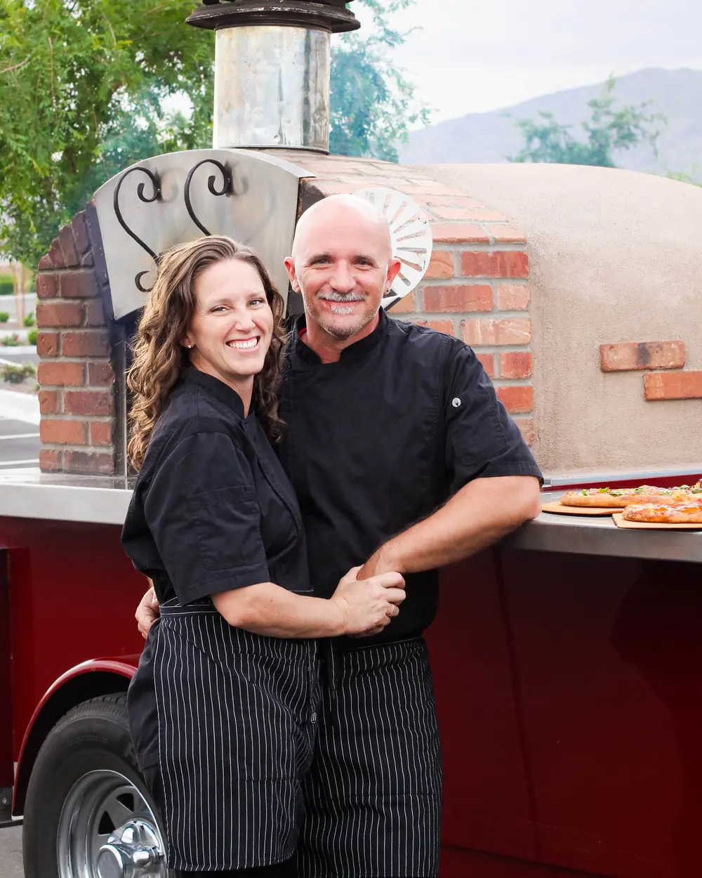 Owners Jamin and Christie Dunn beside their wood-fired oven